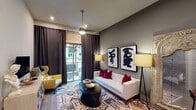 Located at 1025 Preston Rd in Plano, Texas, this thoughtfully designed single-floor residence blends contemporary aesthetics with functional living. The living area sets a sophisticated tone with deep charcoal accent walls, recessed lighting, and large sliding glass doors framed by floor-to-ceiling dark drapes that open to an outdoor balcony, flooding the space with natural light. Bold abstract artwork and an eclectic mix of furnishings add a curated, artistic character to the room.

The kitchen is outfitted with rich dark cabinetry featuring frosted glass inserts, crisp white countertops, and a luminous subway tile backsplash with under-cabinet lighting. Stainless steel appliances, including a side-by-side refrigerator, electric range, built-in microwave, and dishwasher, complete this well-appointed cooking space.

The bedroom offers a serene retreat, anchored by a dramatic upholstered headboard set against a dark feature wall. Large windows frame views of the surrounding greenery, allowing ample natural light to filter through warm golden drapes. Wood-look flooring runs throughout, providing warmth and continuity.

The bathroom features a tub-shower combination with decorative tilework, a single vanity with a white countertop, and direct access to a spacious walk-in closet with organized shelving and hanging storage.