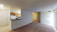 This single-floor residence offers a practical and functional layout designed for comfortable everyday living. The open-concept living area is finished with neutral-toned wall-to-wall carpeting and connects seamlessly to a pass-through kitchen, creating an airy, connected feel throughout the main living space. The kitchen is equipped with warm oak cabinetry, dark speckled countertops, a stainless steel sink, a dishwasher, and a range, providing ample workspace and storage for home cooking. A dedicated dining area sits adjacent to the kitchen, enhancing the flow of the communal spaces.

The bedrooms are generously sized, each featuring plush carpeting and windows fitted with vertical blinds that allow natural light to filter in while maintaining privacy. The rooms offer a clean, neutral palette that accommodates a variety of furnishing styles.

The bathroom is finished with classic white square subway tile surrounding a full soaking tub and shower combination. Chrome fixtures, a mirrored medicine cabinet, a single vanity with sink, and tile flooring complete the space with a clean, timeless aesthetic.

Throughout the unit, the layout is efficient and well-organized, with clear sightlines between living areas and easy access to all rooms, making this a well-rounded residential space suited for a range of occupants.