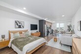 Located at 808 S Western Ave in the heart of Los Angeles' Koreatown neighborhood, this modern studio offers a thoughtfully designed single-floor layout that maximizes every square foot. A clean, well-lit entry hallway — accented by recessed lighting, warm wood-tone flooring, and a patterned area rug — leads into an open-concept living space that seamlessly combines sleeping, lounging, and dining areas. Crisp white walls and light hardwood floors run throughout, creating a bright and cohesive ambiance.

The kitchen is a standout feature, showcasing two-tone cabinetry with light wood uppers and muted blue-gray lowers, white quartz countertops, a sleek tile backsplash, and stainless steel appliances including a French door refrigerator, electric range, microwave, and dishwasher. A full-height glass door opens directly onto a private balcony with open city views, flooding the kitchen with natural light.

The bathroom is finished with large-format stone-look tile flooring, a dark-toned vanity with a white countertop, and a clean, minimalist design. Throughout the unit, the modern aesthetic is consistent — neutral tones, quality materials, and efficient use of space define this well-appointed Los Angeles residence.
