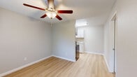 Located at 2020 S Columbus Blvd in Tucson, Arizona, this single-floor unit offers a clean, updated interior designed for comfortable everyday living. The open living area features light hardwood-style flooring and a ceiling fan with a built-in light fixture, creating a bright and airy atmosphere. The kitchen is efficiently designed and outfitted with stainless steel appliances, including an electric range, refrigerator, and dishwasher. White shaker-style cabinetry, granite-look countertops, and an undermount sink complete the kitchen's modern aesthetic. Recessed lighting above the kitchen area provides additional illumination. The bedroom is carpeted for comfort and includes a ceiling fan, a wall-mounted HVAC unit, and a window fitted with blinds that allows natural light to filter in. A dedicated laundry area with stacked washer and dryer hookups is accessible through the bedroom, adding practical convenience. The unit also features a walk-in closet, providing ample storage. Throughout the space, soft gray walls and white trim create a neutral, cohesive palette. Textured ceilings are present in the main living and sleeping areas. The layout is straightforward and functional, making efficient use of the available footprint.