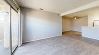Located at 98 S Martin Luther King Blvd in Las Vegas, NV, this single-floor residence offers four bedrooms and two bathrooms within a thoughtfully laid-out floor plan. The open-concept living and dining area features light gray wood-look flooring, neutral-toned walls, a textured ceiling, and a ceiling fan, creating a bright and airy atmosphere. A sliding glass door in the living area fills the space with natural light and provides outdoor access. The kitchen is designed for functionality, showcasing white cabinetry, white appliances including a refrigerator and range, a peninsula with counter seating, an under-cabinet range hood, and a sink — all illuminated by recessed overhead lighting. The four bedrooms are carpeted in neutral tones, offering a comfortable feel, each with closets and textured ceilings. The two bathrooms are clean and straightforward in design, with wood-look tile flooring, white fixtures, and shower-tub combinations — one featuring a walk-in shower stall. Two hallways connect the spaces efficiently throughout the unit. The overall aesthetic is clean, bright, and move-in ready, with a consistent neutral palette that lends itself well to a variety of décor styles.