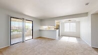 Located at 400 N 96th Ave in Tolleson, Arizona, this single-story, 2-bedroom, 4-bathroom home offers a functional and well-designed layout. The combined kitchen and living area serves as the heart of the home, where the kitchen features white cabinetry, a breakfast bar peninsula, light stone countertops, stainless steel appliances, and hardwood-style flooring. The adjoining living room is bathed in natural light from large windows fitted with horizontal blinds, and includes a ceiling fan overhead. Sliding glass doors open to a private balcony with outdoor views. Both bedrooms are carpeted and bright, with natural light streaming through multiple windows. The spacious primary bedroom includes direct access to two bathrooms and a dedicated walk-in closet with built-in shelving. The bathrooms throughout are finished with white cabinetry, stone-topped vanities, framed mirrors, and hardwood-style flooring, maintaining a clean and consistent aesthetic. Additional closet space and a connecting hallway contribute to efficient use of the floor plan. The overall ambiance is light, neutral, and move-in ready, with a cohesive palette of whites and soft grays throughout.