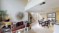 This two-story residence on Summit Vue Drive in Los Angeles, CA offers a thoughtfully designed layout spread across two levels. The main living area immediately impresses with soaring double-height ceilings and a dramatic wall of floor-to-ceiling windows that flood the space with natural light and provide views of lush greenery outside. A fireplace serves as a focal point, complemented by neutral carpet and warm, neutral-toned walls throughout. A staircase connects the two floors with an open feel that enhances the sense of spaciousness.

The dining area sits adjacent to the living room, creating a seamless flow for entertaining. The kitchen is well-appointed with granite countertops, light wood cabinetry, stainless steel appliances including a gas range and built-in microwave, and tile flooring.

The bedrooms offer comfortable retreats, each featuring plush carpeting and windows that bring in natural light. The primary bedroom includes large windows with outdoor views and access to a dedicated bathroom featuring granite countertops and ample vanity space with generous storage. Additional rooms provide flexible use, including a cozy sitting or office area. A dedicated laundry room with a full-size washer and dryer adds everyday convenience.