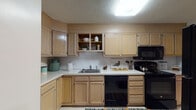 This single-floor residence at 33 Waterfall Dr in Canton, Massachusetts, offers a thoughtfully laid-out living space with distinct areas for relaxing, dining, and sleeping. The kitchen is equipped with light wood cabinetry providing generous storage, white countertops, a stainless sink, and black appliances including a range, built-in microwave, and dishwasher. Light tile flooring runs throughout the kitchen, which connects seamlessly to the rest of the home.

The living room features soft carpeting, a muted blue-gray accent wall, and ample room for seating arrangements, flowing naturally into a dedicated dining area. The dining space is anchored by a pendant light overhead and shares the same cool-toned accent wall, creating a cohesive aesthetic between the two areas.

The bedrooms are carpeted and well-lit by natural light from multiple windows. Each bedroom includes closet space, with one featuring an open walk-in style closet and an additional storage area. The bathroom offers a full tub-shower combination with tiled surround and tile flooring. Overall, the residence presents a clean, functional, and inviting atmosphere throughout.