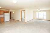 This single-floor residence offers a practical and cohesive layout finished with consistent warm oak wood tones and neutral color palettes throughout. The kitchen is equipped with oak cabinetry providing generous upper and lower storage, light-colored countertops, a double-basin sink, and a full suite of white appliances including an electric range, over-the-range microwave, and refrigerator. Light tile flooring runs through the kitchen, lending durability to the space.

The open living area flows directly from the kitchen and features plush carpeting, a ceiling fan with integrated lighting, and double doors leading to additional storage. The entry door is conveniently accessible from this main living space.

The bedrooms are carpeted and well-lit by multiple windows that invite natural light and exterior views. Ceiling fans are present in each room, and at least one bedroom includes a sliding closet with a hanging rod for organized storage.

Both bathrooms share a consistent design, each featuring tile flooring, an extended vanity with oak cabinetry and a white countertop, a full tub-shower combination, and a toilet. The layout is elongated, providing comfortable circulation within each bathroom. Overall, the unit presents a clean, functional, and move-in ready environment.