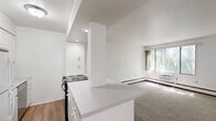 Located at 1005 High Ave in Oshkosh, Wisconsin, this one-bedroom, one-bathroom unit offers a well-organized layout across a single floor. The bedroom is a comfortable, well-proportioned space featuring soft neutral carpeting, crisp white walls, and a ceiling fan with light fixture that provides both airflow and illumination. A set of mirrored sliding closet doors adds a sense of depth and storage convenience, while a baseboard heating unit and a window allowing natural light round out the room's practical features. The kitchen is bright and efficiently designed, showcasing white cabinetry, a clean countertop, wood-look vinyl plank flooring, and a full suite of appliances including a refrigerator, electric range, and dishwasher. Recessed and flush-mount lighting keeps the space well-lit throughout. The bathroom features a full soaking tub with an overhead shower, complemented by built-in wall shelving and a clean, neutral surround. The overall ambiance of the unit is clean and move-in ready, with a consistent light and airy color palette throughout. Its single-level design and straightforward layout make it an easy-to-navigate, functional living space.