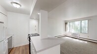 Located at 1005 High Ave in Oshkosh, Wisconsin, this one-bedroom, one-bathroom unit offers a well-organized layout across a single floor. The bedroom is a comfortable, well-proportioned space featuring soft neutral carpeting, crisp white walls, and a ceiling fan with light fixture that provides both airflow and illumination. A set of mirrored sliding closet doors adds a sense of depth and storage convenience, while a baseboard heating unit and a window allowing natural light round out the room's practical features. The kitchen is bright and efficiently designed, showcasing white cabinetry, a clean countertop, wood-look vinyl plank flooring, and a full suite of appliances including a refrigerator, electric range, and dishwasher. Recessed and flush-mount lighting keeps the space well-lit throughout. The bathroom features a full soaking tub with an overhead shower, complemented by built-in wall shelving and a clean, neutral surround. The overall ambiance of the unit is clean and move-in ready, with a consistent light and airy color palette throughout. Its single-level design and straightforward layout make it an easy-to-navigate, functional living space.