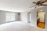 Located at 111 Lafayette Rd in Syracuse, NY, this single-floor residence offers two bedrooms and two bathrooms within a well-organized, functional layout. The open living room serves as the heart of the home, featuring neutral gray walls, plush carpeting, a ceiling fan with light fixture, and a large window that fills the space with natural light and provides outdoor views. Baseboard heating runs throughout, ensuring comfort year-round, complemented by wall-mounted A/C units in key rooms. The kitchen is efficiently designed with warm wood cabinetry, granite-style countertops, hardwood-style flooring, and stainless steel appliances including an electric range and full-size refrigerator. Both bedrooms are carpeted and bright, each featuring windows with blinds and wall-mounted A/C units. The primary bedroom is generously sized with access to an adjoining room, ideal for use as a closet or sitting area. The bathrooms are cleanly finished, with one featuring a wood vanity, granite countertop, a framed mirror, and tile accents. Two hallways connect the rooms, providing a logical and accessible flow throughout the residence. A dedicated closet adds practical storage to round out this comfortable Syracuse home.