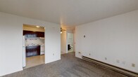 Located at 1901 Union St in Lafayette, Indiana, this one-bedroom, one-bathroom unit offers a practical and straightforward layout across a single floor. The living room is carpeted and features a sliding glass door fitted with vertical blinds, allowing natural light to filter in while providing access to an outdoor view. A ceiling fan is positioned centrally, and a baseboard heating unit runs along the wall, ensuring year-round comfort.

The kitchen is efficiently designed with dark-stained wood cabinetry above and below the countertops, a double-basin sink, a white electric range with coil burners, a dishwasher, and a range hood. The light-toned countertops provide functional prep space in a compact arrangement with tile-style flooring.

The bedroom is a comfortable, carpeted space with a window dressed with horizontal blinds that brings in natural light. A baseboard heater lines the wall, and a closet provides dedicated storage. The neutral white walls and textured ceiling keep the room feeling clean and simple.

The bathroom includes a full tub and shower combination with a curtain, a toilet, and a vanity, finished with resilient tile-style flooring. Overall, the unit features a clean, no-frills design with consistent neutral tones, carpeted living spaces, and practical amenities suited for everyday living.