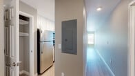 Located at 2401 Broadway St in Vallejo, California, this single-floor unit offers a well-organized and functional layout designed for comfortable everyday living. The kitchen is a standout feature, outfitted with white shaker-style cabinetry extending to the ceiling for ample storage, stainless steel appliances including a refrigerator and microwave, and a peninsula countertop with a warm stone-toned surface that doubles as a breakfast bar. Light wood-style flooring runs throughout the kitchen and living areas, lending a clean and cohesive aesthetic. The open living space is bright and neutrally toned, with recessed lighting and a window that brings in natural light. A hallway with an accessible electrical panel connects the main living area to the private quarters. The bedroom is generously proportioned, featuring soft wall-to-wall carpeting, neutral gray walls, and clean white baseboards, offering a calm and restful environment. The bathroom is finished with light wood-look flooring, white cabinetry with stone-finish countertops, a mirrored vanity, and a tub-shower combination enclosed by sliding glass doors. The overall design maintains a consistent neutral palette throughout, creating a modern and move-in-ready space.
