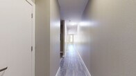 Located at 1000 S Broadway in Denver's vibrant Broadway corridor, this single-floor unit offers a well-designed open-concept layout that combines the kitchen and living areas into one cohesive space. Wood-look flooring runs throughout, lending warmth and visual continuity across every room.

The kitchen is a standout feature, outfitted with dark espresso cabinetry, light quartz countertops, a classic white subway tile backsplash, and a full suite of stainless steel appliances including a refrigerator, range, microwave, and dishwasher. A central island provides additional prep space and a casual dining option, while a pendant light adds a modern touch overhead.

The living area is bright and airy, benefiting from large sliding glass doors that open to a balcony and additional windows that frame views of the surrounding Denver cityscape. A ceiling fan adds comfort and a clean architectural detail to the space.

The bathroom is neatly appointed with wood-look flooring, a tub-shower combination with white tile surround, and a dark wood vanity topped with a light countertop, all finished with chrome hardware. A dedicated closet provides practical storage. The unit's neutral color palette and contemporary finishes create a clean, modern ambiance throughout.