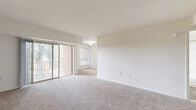 Located at 2000 Maplewood Drive in York, PA, this two-bedroom, one-bathroom residence is spread across two floors, offering a generous and functional layout. The main living level hosts the majority of the space, including a bright, open living room finished with neutral carpet and crisp white walls. Sliding glass doors lead to a private balcony that overlooks a tree-lined courtyard with views of the surrounding neighborhood. The kitchen features white shaker-style cabinetry, light stone countertops, wood-look vinyl flooring, and stainless steel appliances including a refrigerator, gas range, and built-in microwave. The full bathroom is clean and well-appointed, with a tub/shower combo, white vanity, and matching wood-look flooring. The spacious primary bedroom offers generous square footage, plush carpet, and a built-in closet with sliding panel doors. The second bedroom is equally well-lit, with a large window fitted with vertical blinds and ample closet space. Two entrance areas provide convenient access points to the unit, and a dedicated closet adds additional storage. The overall aesthetic is bright and neutral, creating a clean, move-in-ready atmosphere throughout.