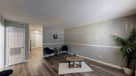 Located at 3151 Harris Dr in East Point, GA, this single-story 2-bedroom, 1-bathroom home offers a clean, modern aesthetic throughout its thoughtfully arranged floor plan. The living room serves as the heart of the home, featuring rich hardwood-style flooring, neutral gray walls accented by crisp white chair rail molding, and a front-facing window that allows natural light to filter in through sheer curtains. The space connects seamlessly to a hallway leading to the rest of the home. The kitchen is well-equipped with white shaker-style cabinetry, granite-look countertops, stainless steel appliances including a range and microwave, and durable wood-look flooring — providing both style and practicality. Both bedrooms are carpeted for comfort, each featuring a double-door closet and neutral gray walls. The primary bedroom offers a generous footprint with room for a full furniture arrangement. The bathroom is finished with a tub-shower combination accented by marble-look tile surround, providing a clean and polished look. A dedicated hallway connects all rooms efficiently, contributing to the home's cohesive and functional flow. Overall, the space presents a move-in-ready environment with consistent, contemporary finishes throughout.