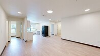 Located at 2732 Forest Ave in Kansas City, MO, this thoughtfully designed 3-bedroom, 2-bathroom unit offers a clean, modern aesthetic across a single floor. Light wood-style flooring and crisp white walls flow consistently throughout, creating a bright and cohesive interior.

The open living area features recessed lighting and a neutral palette, providing a versatile canvas for any furnishing style. The well-appointed kitchen is a standout, offering white shaker-style cabinetry with matte black hardware, light countertops, a stainless steel sink, and black appliances including a refrigerator, dishwasher, and range. A large window above the counter fills the kitchen with natural light and frames views of the surrounding greenery.

Three bedrooms offer comfortable proportions, with the primary bedroom providing a generous footprint. Each bedroom benefits from natural light through blinds-fitted windows with outdoor views. The two bathrooms are finished with light wood-style flooring, white vanities with undermount sinks and large mirrors, and one features a full soaking tub with a curved shower curtain rod. A connecting hallway ties the layout together efficiently. Throughout, dark baseboards provide a clean contrast, lending the space a polished, move-in-ready feel.