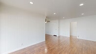 Located at 7550 Fountain Ave in the heart of West Hollywood, this well-appointed 1-bedroom, 1-bathroom residence offers a thoughtfully designed single-floor layout with clean, modern finishes throughout. Rich hardwood flooring flows seamlessly across every room, anchoring the bright, white-walled interior in warmth and continuity.

The open living and dining area is spacious and versatile, featuring recessed lighting, a ceiling fan, and a large sliding door covered by vertical blinds that allows natural light to fill the room. The galley-style kitchen is a standout, outfitted with white shaker cabinetry extending to the ceiling, marble-look countertops, a full suite of stainless steel appliances including a gas range, built-in microwave, refrigerator, and dishwasher, plus a window above the sink for added brightness.

The bedroom is generously sized and includes a ceiling fan, a wall-unit AC, a wide window with vertical blinds, and a mirrored sliding closet. Additional storage is provided by four closets throughout the unit. The bathroom features classic white subway tile in the tub/shower surround, a marble-topped vanity, hexagonal floor tile, and a frosted window for natural light. A hallway connects the rooms with ease, completing this efficient and stylish layout.