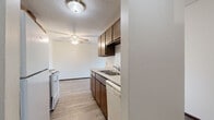 Located at 2044 Oakdale Ave in West St. Paul, MN, this single-floor, 3-bedroom, 2-bathroom unit offers a practical and comfortable layout. The open kitchen and living area form the heart of the home, with the kitchen featuring dark wood cabinetry, white appliances including an electric range and dishwasher, a double sink, and a textured ceiling. Light wood-style luxury vinyl flooring runs throughout the main living areas, complemented by a ceiling fan that enhances airflow and comfort. The living room is bright and open, with a sliding glass door leading to a private balcony that provides pleasant outdoor views of the surrounding greenery. The three bedrooms are carpeted for warmth and comfort, with vertical panel accent walls adding a subtle design touch. The primary bedroom includes a spacious closet with built-in shelving for organized storage. Both bathrooms are well-appointed — one features a full tub/shower combo with a clean white surround, and the other offers a white vanity with a granite-style countertop, a large mirror, and wood-style flooring. Baseboard heating is present throughout, and the unit includes dedicated closet spaces for added storage convenience.