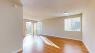 Located in North Hollywood's 91602 zip code, this single-floor, 3-bedroom, 4-bathroom residence on Valley Spring Lane offers a well-organized and comfortable layout. The living room is a bright, welcoming space featuring warm hardwood flooring, a textured ceiling, and a corner fireplace. Large sliding glass doors open to a balcony, allowing abundant natural light to stream across the room, while an additional window further enhances the airy atmosphere.

The galley-style kitchen is efficiently designed with marble-patterned countertops, white cabinetry, stainless steel appliances including a gas range, microwave, and dishwasher, and light wood-look flooring. It connects seamlessly to the hallway for easy flow throughout the unit.

The three bedrooms are finished with plush carpeting and feature vertical blind-covered windows that invite soft, natural light. The generously sized primary bedroom includes a mirrored closet and ample wall space. The four bathrooms are clean and functional, featuring tile flooring, white vanities with large mirrors, and glass-enclosed shower units.

Throughout the residence, neutral warm-toned walls and consistent finishes create a cohesive and inviting ambiance, making this North Hollywood home a practical and comfortable living space.