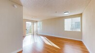 Located in North Hollywood's 91602 zip code, this single-floor, 3-bedroom, 4-bathroom residence on Valley Spring Lane offers a well-organized and comfortable layout. The living room is a bright, welcoming space featuring warm hardwood flooring, a textured ceiling, and a corner fireplace. Large sliding glass doors open to a balcony, allowing abundant natural light to stream across the room, while an additional window further enhances the airy atmosphere.

The galley-style kitchen is efficiently designed with marble-patterned countertops, white cabinetry, stainless steel appliances including a gas range, microwave, and dishwasher, and light wood-look flooring. It connects seamlessly to the hallway for easy flow throughout the unit.

The three bedrooms are finished with plush carpeting and feature vertical blind-covered windows that invite soft, natural light. The generously sized primary bedroom includes a mirrored closet and ample wall space. The four bathrooms are clean and functional, featuring tile flooring, white vanities with large mirrors, and glass-enclosed shower units.

Throughout the residence, neutral warm-toned walls and consistent finishes create a cohesive and inviting ambiance, making this North Hollywood home a practical and comfortable living space.