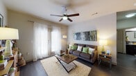 Located at 1810 E Sonterra Blvd in San Antonio, TX, this single-floor residence offers a thoughtfully designed layout with modern finishes and a cohesive aesthetic throughout. The open-concept kitchen is a standout feature, showcasing rich dark cabinetry, granite countertops, a large center island with pendant lighting and bar seating, a subway tile backsplash, and a full suite of stainless steel appliances. Track lighting and under-cabinet lighting enhance both functionality and ambiance in this space. The kitchen flows seamlessly into the living area, which features dark hardwood-style flooring, a ceiling fan, and large windows with sheer curtains that invite abundant natural light. A sliding glass door provides access to the outdoors. The bedrooms are well-sized, each equipped with ceiling fans, carpeted floors, and generously sized windows that allow plenty of natural light. The primary bedroom connects to a private bathroom featuring granite countertops, dark cabinetry, hardwood-style flooring, and a walk-in closet with built-in shelving. A second bathroom offers a full tub-shower combination with matching granite and dark vanity finishes. The residence presents a consistent, modern design language with neutral tones and quality materials throughout.