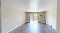 Located at 651 Schiller St in Sun Prairie, Wisconsin, this single-floor, two-bedroom, one-bathroom residence offers a practical and well-appointed layout. The combined kitchen and living area forms the heart of the home, where the kitchen stands out with warm wood cabinetry, granite-style countertops, stainless steel refrigerator, and an electric range with hood ventilation. Light hardwood-style flooring runs throughout the kitchen and living area, creating a cohesive, easy-to-maintain surface. The living room is bright and open, benefiting from a sliding glass patio door that fills the space with natural light and provides outdoor views of the surrounding greenery. A ceiling fan adds comfort and airflow to this shared area. Both bedrooms are finished with plush carpeting, ceiling fans, and windows that invite natural light. The primary bedroom offers a generous walk-in closet with dual shelving on both sides, maximizing storage. The second bedroom features a sliding panel closet. The full bathroom is clean and functional, equipped with a full-size soaking tub and shower combination. Throughout the residence, neutral wall tones and consistent finishes create a calm, cohesive ambiance well-suited for comfortable everyday living.