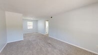 Located at 524 W Tharpe St in Tallahassee, FL, this single-floor, 3-bedroom, 3-bathroom residence offers a practical and well-organized layout. The combined living and dining area provides a versatile open space with neutral light gray walls, plush carpeting, and a textured ceiling, creating a clean and comfortable atmosphere throughout.

The kitchen features white cabinetry, light countertops, a double-basin stainless steel sink, and stainless steel appliances including a range and over-the-range microwave. Light wood-style flooring runs through the kitchen, complemented by an adjacent pantry for added storage convenience.

Each of the three bedrooms is carpeted and painted in soft, neutral tones, allowing ample natural light through windows fitted with blinds. Two of the bedrooms include ceiling fans with light fixtures, enhancing comfort year-round. The spacious primary bedroom includes a private en-suite bathroom access, while four closets distributed throughout the unit ensure generous storage capacity.

The three bathrooms are finished with white tile work, including subway-tiled shower surrounds, light vanities with mirrors, and wood-style flooring. A dedicated laundry area adds everyday convenience. The entry foyer transitions smoothly from light wood-style flooring to carpet, setting a welcoming tone from the moment you step inside.