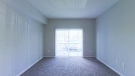 Located at 785 Cross Pointe Road in Gahanna, Ohio, this single-floor residence offers a clean, straightforward layout designed for comfortable everyday living. The interior features neutral gray walls that create a calm, versatile backdrop, making it easy to personalize the space to any style. Plush wall-to-wall carpeting runs throughout the living area, adding warmth and a sense of coziness underfoot. A standout feature of the main living space is the full-height sliding glass door dressed with vertical blinds, which floods the room with abundant natural light and provides direct access to an outdoor area. The textured ceiling adds a subtle architectural detail overhead, while clean white baseboards frame the room with a crisp, finished look. The overall ambiance is bright, open, and move-in ready, with a minimalist aesthetic that allows residents to envision and craft their ideal living environment. Situated in Gahanna, OH, the property benefits from a well-established community setting, offering convenient access to local amenities, dining, shopping, and major thoroughfares in the Columbus metropolitan area.