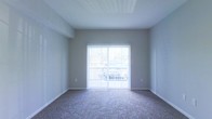 Located at 785 Cross Pointe Road in Gahanna, Ohio, this single-floor residence offers a clean, straightforward layout designed for comfortable everyday living. The interior features neutral gray walls that create a calm, versatile backdrop, making it easy to personalize the space to any style. Plush wall-to-wall carpeting runs throughout the living area, adding warmth and a sense of coziness underfoot. A standout feature of the main living space is the full-height sliding glass door dressed with vertical blinds, which floods the room with abundant natural light and provides direct access to an outdoor area. The textured ceiling adds a subtle architectural detail overhead, while clean white baseboards frame the room with a crisp, finished look. The overall ambiance is bright, open, and move-in ready, with a minimalist aesthetic that allows residents to envision and craft their ideal living environment. Situated in Gahanna, OH, the property benefits from a well-established community setting, offering convenient access to local amenities, dining, shopping, and major thoroughfares in the Columbus metropolitan area.