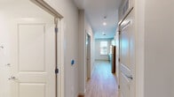Located at 2119 Post Rd in Warwick, Rhode Island, this thoughtfully designed one-bedroom, one-bathroom unit offers a clean, modern living experience across a single floor. Light-toned hardwood-style flooring runs throughout, lending warmth and visual continuity to the space.

The open-concept area seamlessly integrates the kitchen, dining, and living room into a bright, functional hub. The kitchen is a standout feature, showcasing two-tone cabinetry — muted teal lower cabinets paired with natural wood upper cabinets — set against a classic white subway tile backsplash. Stainless steel appliances, including a range, dishwasher, microwave, and refrigerator, complement the crisp white countertops. Generous windows flood the kitchen and living area with natural light and offer views of the surrounding neighborhood.

A central hallway connects the main living area to the private spaces, including the bedroom, bathroom, and two closets. The bedroom is a comfortable, well-proportioned retreat with neutral walls and easy access to storage. The bathroom features a glass-enclosed walk-in shower finished with white subway tile and brushed nickel fixtures, conveying a clean and polished aesthetic.

Additional conveniences include a dedicated laundry area and a utility room, making this a highly functional and well-appointed unit.