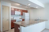 Located at 2864 Pleasant View Rd in Middleton, Wisconsin, this 2-bedroom, 1-bathroom single-floor residence offers a practical and comfortable layout designed for everyday living. The open-concept living and kitchen area forms the heart of the home, where rich cherry wood cabinetry, granite-style countertops, and white appliances — including a range, microwave, and refrigerator — define the kitchen space. A peninsula counter provides a natural transition into the carpeted living room, which is brightened by a ceiling fan, a sliding glass door with vertical blinds, and an additional window that invites natural light. The two bedrooms feature soft wall-to-wall carpeting and neutral tones. The primary bedroom is generously sized and includes a dedicated closet, while the second bedroom offers a bright window with an outdoor view. The full bathroom is well-appointed with rich wood vanity cabinetry, a large mirror with overhead lighting, tile flooring, and a full tub-shower combination. A dedicated in-unit laundry area houses a full-sized washer and dryer, adding everyday convenience. Clean lines, consistent neutral tones, and tile flooring in wet areas give the space a cohesive, move-in-ready aesthetic throughout.