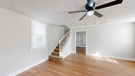 Located at 403 Holly Ln in Dothan, Alabama, this two-story home offers three bedrooms, two bathrooms, and a functional layout spread across two floors. The main level provides generous living space, featuring warm hardwood-style flooring throughout the living areas and a bright, open feel enhanced by multiple windows with white blinds. A ceiling fan with light fixture adds comfort to the main living room, which also features a carpeted staircase leading to the upper level. The kitchen is equipped with white shaker-style cabinetry, marble-look countertops, a stainless steel double sink with a matte black faucet, and a stainless steel dishwasher, all complemented by a large window that brings in natural light. The two full bathrooms are thoughtfully finished — one features grey subway tile surrounding a full tub-shower combo with matte black fixtures, while the second offers a clean, neutral design with a window for natural ventilation. The bedrooms include a spacious primary suite with plush carpet flooring and multiple windows, while additional bedrooms feature hardwood-style flooring and ample natural light. Neutral wall tones and clean white trim throughout create a cohesive, move-in-ready aesthetic across the entire home.