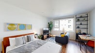 Located at 1024 S King St in Seattle, WA, this efficiently designed single-floor unit makes excellent use of its compact footprint. Light wood-style flooring runs throughout, creating a warm and cohesive aesthetic across all areas of the space.

The galley-style kitchen is a standout feature, outfitted with light wood cabinetry accented by matte black hardware, quartz-style countertops, a white tile backsplash, and a full suite of stainless steel appliances including a range, over-the-range microwave, dishwasher, and a tall French-door refrigerator. Under-cabinet lighting adds both practicality and ambiance.

The bathroom continues the modern design language with a warm wood vanity, integrated sink with contemporary fixtures, a large mirror, and recessed overhead lighting — all set against crisp white walls and matching wood-style flooring.

A dedicated walk-in closet offers wire shelving, hanging rods, and additional dresser storage, providing ample organizational space. The living area, visible in the floorplan overview, features a window with outdoor views, bringing in natural light. In-unit laundry adds a convenient, practical amenity. The overall design is clean, contemporary, and thoughtfully laid out to maximize functionality throughout every area of the space.