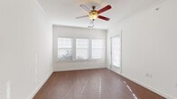 Located at 1309 Winkler Ave in Killeen, Texas, this single-story home offers a clean, modern interior with a cohesive design aesthetic throughout. The living area is a standout space, featuring rich wood-look flooring, crisp white walls with crown molding, and a ceiling fan with a light fixture that adds both function and character. Large windows dressed with white horizontal blinds allow generous natural light to fill the room, creating a bright and welcoming atmosphere.

The kitchen is well-appointed with dark espresso cabinetry providing ample upper and lower storage, light-toned countertops, and a full suite of black appliances including a refrigerator, electric range, and built-in microwave. A peninsula counter connects the kitchen to the adjacent living space, creating an open, functional layout. A doorway from the kitchen leads to a dedicated laundry area, adding practical convenience.

The bedrooms offer comfortable accommodations, with one room showcasing the same wood-look flooring and multiple windows, while another features plush neutral carpet and a window with natural views. The bathroom is finished with dark vanity cabinetry, a light countertop, a large mirror, wood-look flooring, and a tiled tub-shower combination, completing the home's consistent and practical design.