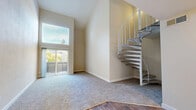 Located at 2380 Sierra Blvd in Sacramento, CA, this two-story, 3-bedroom, 4-bathroom home offers a well-designed layout across two floors. The main level provides the larger share of the living space and features an open living area with soaring vaulted ceilings, abundant natural light from oversized windows, and sliding glass doors that open to the outdoors. A distinctive white spiral staircase serves as a central architectural focal point, connecting the two levels with both style and efficiency. The kitchen is outfitted with white cabinetry, light quartz countertops, stainless steel appliances including a range, microwave, refrigerator, and dishwasher, all set on warm wood-style flooring. A ceiling fan enhances airflow in the main living area. The three bedrooms are bright and well-proportioned, with carpeted or wood-style flooring, neutral wall tones, and windows offering garden views. The primary bedroom includes a walk-in closet with built-in shelving. The four bathrooms are clean and functional, each featuring tub-shower combinations and wood-style flooring. Two dedicated closets provide additional storage. The upper floor offers a more intimate, versatile space ideal for additional bedrooms or a private retreat.
