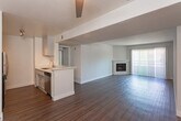 Located on Cahuenga Boulevard in the North Hollywood area of Los Angeles, this single-story unit offers a well-organized layout with a cohesive, neutral design throughout. The open living area is anchored by a fireplace with a white mantel and features dark hardwood-style flooring that extends through the main living spaces. Sliding glass doors and vertical blinds allow natural light to pour in while providing access to outdoor views.

The kitchen is thoughtfully designed with a peninsula counter featuring a stone-look surface and double sink, gray cabinetry, track lighting, and stainless steel appliances including a gas range, microwave, and refrigerator. The peninsula creates a natural transition between the kitchen and the living area, which also includes a ceiling fan.

The bedrooms are carpeted and generously sized, benefiting from large windows dressed with vertical blinds that invite natural light. One bedroom features a mirrored sliding closet, adding a sense of depth to the space.

The bathroom is finished with wood-style flooring, a white vanity with ample storage, and a tub-shower combination. Throughout the unit, clean white walls and consistent finishes create a bright, move-in-ready atmosphere suited for comfortable everyday living.
