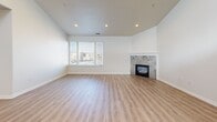 Located at 739 S 300 W in Salt Lake City, Utah, this well-appointed single-floor residence offers three bedrooms, five bathrooms, and a thoughtfully designed layout that balances comfort and functionality. The open-concept living room is a standout, featuring vaulted ceilings, light wood-style flooring, recessed lighting, and a tile-surround fireplace that serves as a natural focal point. A large window fills the space with natural light and offers views of the surrounding cityscape. The kitchen is highlighted by soaring ceilings, bold cherry-red cabinetry, granite countertops, stainless steel appliances including a double wall oven and French door refrigerator, and a spacious center island with a built-in sink — ideal for both cooking and entertaining. The generously sized primary bedroom provides a quiet retreat with plush carpeting and dedicated closet space. Additional bedrooms are carpeted and feature windows that bring in natural light. The five bathrooms are clean and functional, finished with wood-style flooring and neutral tones. A dedicated utility room, four closets, and two hallways round out the layout, providing ample storage and easy circulation throughout the home.