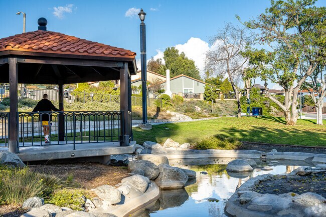 The gazebo at Taylor Ranch Park is surrounded by ponds, grassy hills, and running water