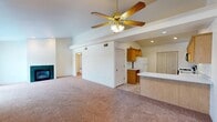 This single-floor residence offers a practical and comfortable layout with a cohesive, neutral design throughout. The open-concept living area is anchored by a ceiling fan with a light fixture and features plush wall-to-wall carpeting, a fireplace, and a seamless connection to the kitchen via a breakfast bar. The kitchen is well-equipped with warm wood cabinetry, white countertops, a gas range, refrigerator, microwave, and a double-basin sink, all set atop durable tile flooring. Recessed lighting and vaulted-style ceilings lend the kitchen an airy, functional feel, along with a dedicated closet for additional storage.

The bedrooms are generously sized, each with soft carpeting and ceiling fans. One bedroom features large sliding glass doors that invite natural light and outdoor views, while another benefits from a bright picture window overlooking mature trees. Ample closet space is provided throughout, including double-door closets. The bathrooms include a full bath with a tub-shower combo and a vanity with wood cabinetry, as well as a second bath with a walk-in shower stall. A dedicated laundry area with a full-size washer and dryer adds everyday convenience, completing this well-rounded and move-in-ready home.