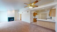 This single-floor residence offers a practical and comfortable layout with a cohesive, neutral design throughout. The open-concept living area is anchored by a ceiling fan with a light fixture and features plush wall-to-wall carpeting, a fireplace, and a seamless connection to the kitchen via a breakfast bar. The kitchen is well-equipped with warm wood cabinetry, white countertops, a gas range, refrigerator, microwave, and a double-basin sink, all set atop durable tile flooring. Recessed lighting and vaulted-style ceilings lend the kitchen an airy, functional feel, along with a dedicated closet for additional storage.

The bedrooms are generously sized, each with soft carpeting and ceiling fans. One bedroom features large sliding glass doors that invite natural light and outdoor views, while another benefits from a bright picture window overlooking mature trees. Ample closet space is provided throughout, including double-door closets. The bathrooms include a full bath with a tub-shower combo and a vanity with wood cabinetry, as well as a second bath with a walk-in shower stall. A dedicated laundry area with a full-size washer and dryer adds everyday convenience, completing this well-rounded and move-in-ready home.