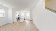 Located at 6565 E Woodmen Rd in Colorado Springs, CO, this two-story home offers a clean, modern design spread evenly across two floors. The main level features an open-concept kitchen and living area bathed in natural light from multiple windows. The kitchen is a standout, showcasing white shaker cabinetry, a classic subway tile backsplash, a marble-topped center island with pendant lighting, and a full suite of stainless steel appliances. Light wood-look flooring flows throughout the main level, enhancing the bright, airy atmosphere. The living area is spacious and sun-filled, with ceiling fans adding comfort. Upstairs, two well-appointed bedrooms feature plush carpeting, ceiling fans, and windows that allow ample natural light. The primary bedroom includes a walk-in closet with wire shelving. Three bathrooms serve the home, including one with a full tub-shower combination finished in clean white with chrome fixtures. A dedicated laundry area houses a full-size washer and dryer. The attached garage provides convenient parking and additional storage. The home's consistent white palette and modern finishes create a cohesive, move-in-ready living environment.