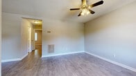 Located at 613 Jefferson St in Kernersville, NC, this single-floor, 3-bedroom, 1-bathroom home offers a practical and comfortable layout. The living areas feature light gray laminate wood flooring throughout, complemented by neutral-toned walls and crisp white baseboards that create a clean, cohesive aesthetic. Ceiling fans with integrated lighting are present in the main living areas and bedrooms, providing both comfort and illumination. The kitchen is a functional highlight, featuring white cabinetry, white subway tile backsplash, light countertops, and black appliances — including a range, dishwasher, and refrigerator — alongside a window that brings in natural light. The three bedrooms are fitted with plush carpet flooring and each includes a closet with a bi-fold door and a ceiling fan. One bedroom features a window with a pleasant outdoor view of surrounding greenery. The bathroom includes a full tub and shower combination with clean white surround panels. A hallway connects the rooms, and a dedicated closet provides additional storage. The textured ceilings add a classic touch throughout the home, rounding out this well-organized and move-in ready residence.