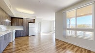 Located on 10th St E in Palmdale, CA, this well-appointed 3-bedroom, 2-bathroom home offers a thoughtfully designed single-floor layout. The open-concept living, dining, and kitchen area serves as the heart of the home, featuring warm wood-look flooring, clean white walls, and abundant natural light. The kitchen is equipped with wood-tone cabinetry, white appliances including a refrigerator and range, and a functional countertop with a sink — all flowing seamlessly into the dining and living spaces. A private balcony extends the living area outdoors, offering sweeping mountain views of the Palmdale landscape. Each of the three bedrooms is bright and airy, filled with natural sunlight through well-placed windows. The generously sized primary bedroom provides a comfortable retreat with ample space. Storage is plentiful throughout, with six closets including walk-in options fitted with wire shelving systems. The two bathrooms are finished with wood-look flooring, white tile tub-shower surrounds, and modern vanities with wood-tone cabinetry. A hallway connects the private and shared spaces efficiently. The overall aesthetic is clean, contemporary, and functional, making this a practical and comfortable home in the heart of Palmdale.