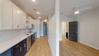 Studio-A1E at 323 is a thoughtfully designed single-floor studio that blends modern finishes with a functional, open layout. Light wood-tone flooring runs throughout, lending warmth and visual continuity to the entire space.

The galley-style kitchen is a standout feature, outfitted with crisp white upper cabinetry, dark lower cabinets, and a classic subway tile backsplash. A full suite of stainless steel appliances — including a refrigerator, over-the-range microwave, and dishwasher — accompanies a deep undermount sink with a pull-down faucet and white quartz countertops, creating a clean, contemporary aesthetic.

The open living area offers a comfortable, flexible footprint bathed in natural light from a large window fitted with blinds. A ceiling fan keeps the space airy and comfortable year-round.

The full bathroom is finished with the same attention to detail, featuring dark cabinetry with brushed gold hardware, a white quartz double vanity, a framed mirror, and a soaking tub surrounded by white subway tile.

A generously sized walk-in closet with multi-tier wire shelving and hanging rods provides ample storage. Dark-paneled interior doors add a bold, modern contrast throughout the studio, completing the polished, cohesive design.