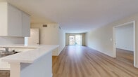 Located at 5633 Colfax Ave in North Hollywood, this 2-bedroom, 1-bathroom unit offers a well-designed, single-floor layout with a clean, modern aesthetic throughout. Light wood flooring extends across every room, creating a cohesive and bright atmosphere.

The open living room is generously sized, featuring a sliding glass door that opens onto a private balcony, filling the space with natural light and providing outdoor access. Adjacent to the living area, the kitchen is efficiently laid out with white cabinetry, a white quartz peninsula countertop, stainless steel appliances including a range, refrigerator, and dishwasher, along with an under-cabinet range hood.

The spacious primary bedroom features mirrored sliding closet doors and benefits from natural light through large windows. The second bedroom is well-proportioned, offering a sliding closet and a ceiling light fixture, making it suitable as a guest room or home office. A hallway connects the bedrooms to the shared full bathroom, which includes a combined tub and shower, a white vanity with a single sink, and a large mirror.

Throughout the unit, neutral wall tones and consistent wood-look flooring contribute to a clean, move-in-ready environment well-suited for comfortable everyday living in Los Angeles.