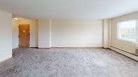 Located at 3955 N Murray Ave in the village of Shorewood, Wisconsin, this single-floor residence offers a practical and comfortable layout across several well-defined living spaces. The expansive living room features soft wall-to-wall carpeting, warm neutral tones, and a ceiling fan, creating a bright and open atmosphere. A built-in cabinet with glass-front doors adds a classic touch and provides convenient display and storage space.

The kitchen is efficiently designed with wood-trimmed white cabinetry, white laminate countertops, and a full suite of appliances including a coil-burner electric range, dishwasher, and a top-freezer refrigerator. A range hood and a deep single-basin sink round out the functional layout, while vinyl flooring adds easy maintenance underfoot.

The bedrooms are generously sized, each outfitted with plush carpeting, ceiling fans with light fixtures, and baseboard heating. Both rooms feature bifold closet doors — one bedroom offering a single closet and the other boasting a double closet configuration, providing excellent storage capacity.

The full bathroom is finished with light ceramic tile flooring, a wood-trimmed vanity, and a combined tub and shower. Clean, neutral finishes throughout create a cohesive and move-in ready environment suited for comfortable everyday living.