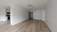 Located at 2332 S Bentley Ave in Los Angeles, this well-appointed 2-bedroom, 2-bathroom residence offers a clean, modern aesthetic throughout its single-floor layout. Light-toned hardwood flooring runs continuously across the space, lending warmth and cohesion to every room. The open living area is bright and airy, benefiting from a large sliding glass door dressed with vertical blinds that frames greenery outside and allows natural light to pour in. The kitchen is thoughtfully updated with white shaker cabinetry, subway tile backsplash, stainless steel appliances including a range, dishwasher, microwave, and refrigerator, and ample counter and storage space. Both bedrooms are generously sized, each featuring large windows with vertical blinds that bring in plentiful natural light and views of the surrounding neighborhood. Sliding closet doors provide practical storage in the bedrooms, complemented by five closets throughout the unit. The bathrooms are finished in a crisp, contemporary style, with one featuring a full tub-shower combination adorned with elegant herringbone tile and a glass enclosure. A connecting hallway ties the layout together efficiently. The overall ambiance is bright, neutral, and move-in ready.