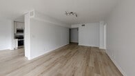 Located at 2332 S Bentley Ave in Los Angeles, this well-appointed 2-bedroom, 2-bathroom residence offers a clean, modern aesthetic throughout its single-floor layout. Light-toned hardwood flooring runs continuously across the space, lending warmth and cohesion to every room. The open living area is bright and airy, benefiting from a large sliding glass door dressed with vertical blinds that frames greenery outside and allows natural light to pour in. The kitchen is thoughtfully updated with white shaker cabinetry, subway tile backsplash, stainless steel appliances including a range, dishwasher, microwave, and refrigerator, and ample counter and storage space. Both bedrooms are generously sized, each featuring large windows with vertical blinds that bring in plentiful natural light and views of the surrounding neighborhood. Sliding closet doors provide practical storage in the bedrooms, complemented by five closets throughout the unit. The bathrooms are finished in a crisp, contemporary style, with one featuring a full tub-shower combination adorned with elegant herringbone tile and a glass enclosure. A connecting hallway ties the layout together efficiently. The overall ambiance is bright, neutral, and move-in ready.