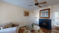 Located in El Paso, TX, this single-story, 1-bedroom, 2-bathroom home offers a well-organized and efficient layout across its single floor. The living room serves as the heart of the space, showcasing rich hardwood flooring, a textured ceiling with a ceiling fan, and a striking wood-burning fireplace framed in dark tile — an eye-catching focal point complemented by large windows that invite natural light. Adjacent to the living area, a dedicated dining space provides a seamless transition to the kitchen, which features warm honey-toned cabinetry, granite-look countertops, a pass-through window connecting it to the living and dining areas, and black appliances. The bedroom offers a comfortable retreat with soft carpeting, a large window with outdoor views, and access to two closets providing generous storage. A hallway lined with built-in shelving adds additional organizational functionality. Two full bathrooms serve the home, one featuring a classic tiled tub-shower combination. The hallways connect the rooms efficiently, maintaining a cohesive and practical flow throughout. With neutral tones, consistent finishes, and a functional floor plan, this home presents a comfortable and well-appointed living environment.