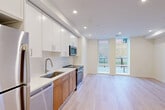 Located at 509 Kennedy St NW in Washington, DC, this modern 1-bedroom, 2-bathroom residence offers a thoughtfully designed open-concept layout with contemporary finishes throughout. Light hardwood flooring runs seamlessly across the entire unit, complementing the clean, neutral color palette that enhances the sense of openness.

The combined dining, kitchen, and living area serves as the heart of the home. The kitchen is outfitted with two-tone cabinetry — white upper cabinets paired with warm wood lower cabinets — topped with white quartz countertops and a classic white tile backsplash. Stainless steel appliances, including a range, microwave, and dishwasher, complete the functional space. Large floor-to-ceiling windows and a glass door flood the living area with natural light and offer views of the outdoor surroundings.

The spacious bedroom features recessed lighting, crisp white walls, and ample room for furnishings. Two closets provide generous storage. A hallway connects all areas of the unit, with one bathroom featuring a clean white vanity with quartz countertop, warm wood cabinetry, and brushed nickel fixtures. In-unit laundry adds everyday convenience. The second bathroom offers additional functionality for guests. Recessed lighting throughout creates a bright, modern ambiance.
