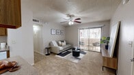Located at 2500 N Desert Links Dr in Tucson, AZ, this single-floor, 2-bedroom, 2-bathroom home offers a well-organized layout designed for everyday comfort. The living room features soft carpeting, a ceiling fan, and a sliding glass door fitted with vertical blinds that opens to a private patio, bringing in natural light and outdoor views. The kitchen is outfitted with warm wood-toned cabinetry, a peninsula with counter seating, white appliances, and a pendant light, flowing seamlessly into the adjacent dining area. The dining space is accented by wood-look flooring, a large window, and a stylish overhead light fixture, creating a bright and inviting setting for meals. Both bedrooms are carpeted and offer a calm, neutral palette; the primary bedroom is generously sized, while the second bedroom features natural light from a window with sheer curtains. Each bathroom includes a wood-vanity with granite-style countertops, a large mirror, and a shower. A hallway with wood-look flooring connects the main living areas to the private quarters, and a dedicated closet provides additional storage. Textured ceilings are consistent throughout, adding a characteristic architectural detail to the home's overall aesthetic.