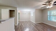 Located at 100 Camellia Ln in Stonecrest, Georgia, this single-story, one-bedroom, one-bathroom residence offers a practical and comfortable layout. The living room is a welcoming open space featuring durable wood-style flooring, neutral wall tones, and a ceiling fan with light fixture. Multiple windows allow natural light to fill the room, and a glass-paneled door provides direct outdoor access, offering pleasant views of surrounding greenery. A pendant light fixture adds a subtle decorative touch to the dining area nearby.

The kitchen is efficiently designed with white cabinetry, light stone-finish countertops, and black appliances including a range and refrigerator. An adjacent closet with built-in wire shelving provides convenient pantry or storage space.

The bedroom is carpeted for comfort, featuring a large window that brings in natural light and views of the outdoors. It includes a closet and connects to additional storage, offering a well-organized personal space.

The bathroom is clean and functional, equipped with a tub-shower combo with white tile surround, a single-sink vanity with white cabinetry and a stone-finish countertop, and a large mirror. Wood-style flooring continues here, tying the aesthetic together.

Throughout, textured ceilings, white trim, and a cohesive neutral palette create a consistent, move-in-ready environment.